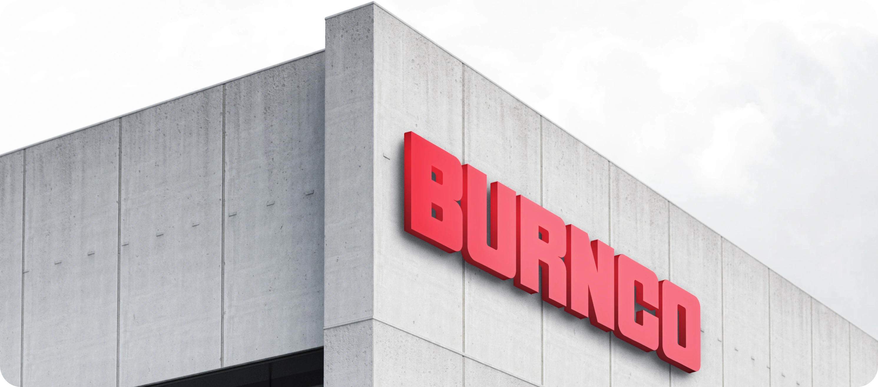 The BURNCO wordmark in red, mounted on the concrete façade of one of its buildings.